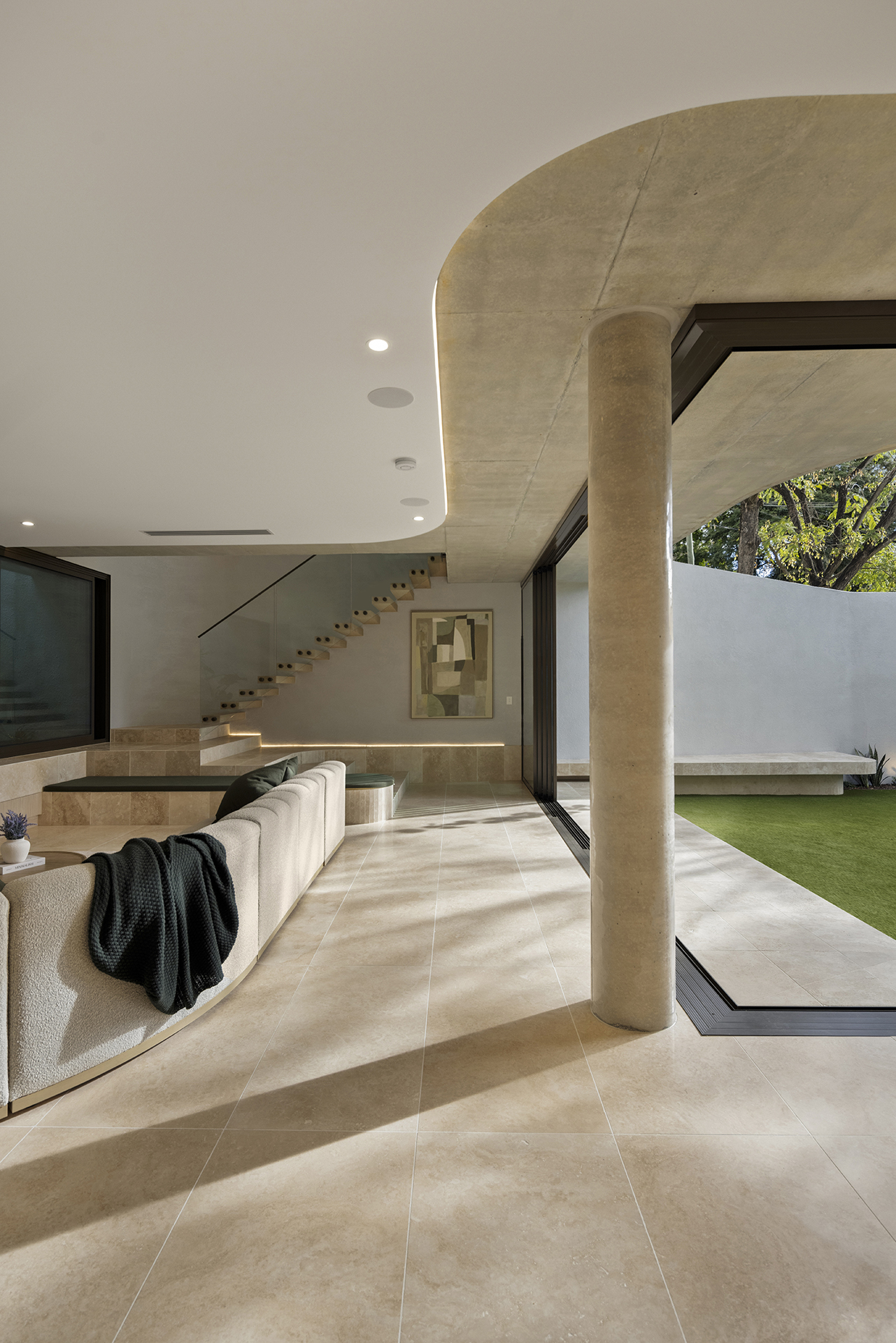 Sculptural curves and travertine columns framing the central courtyard