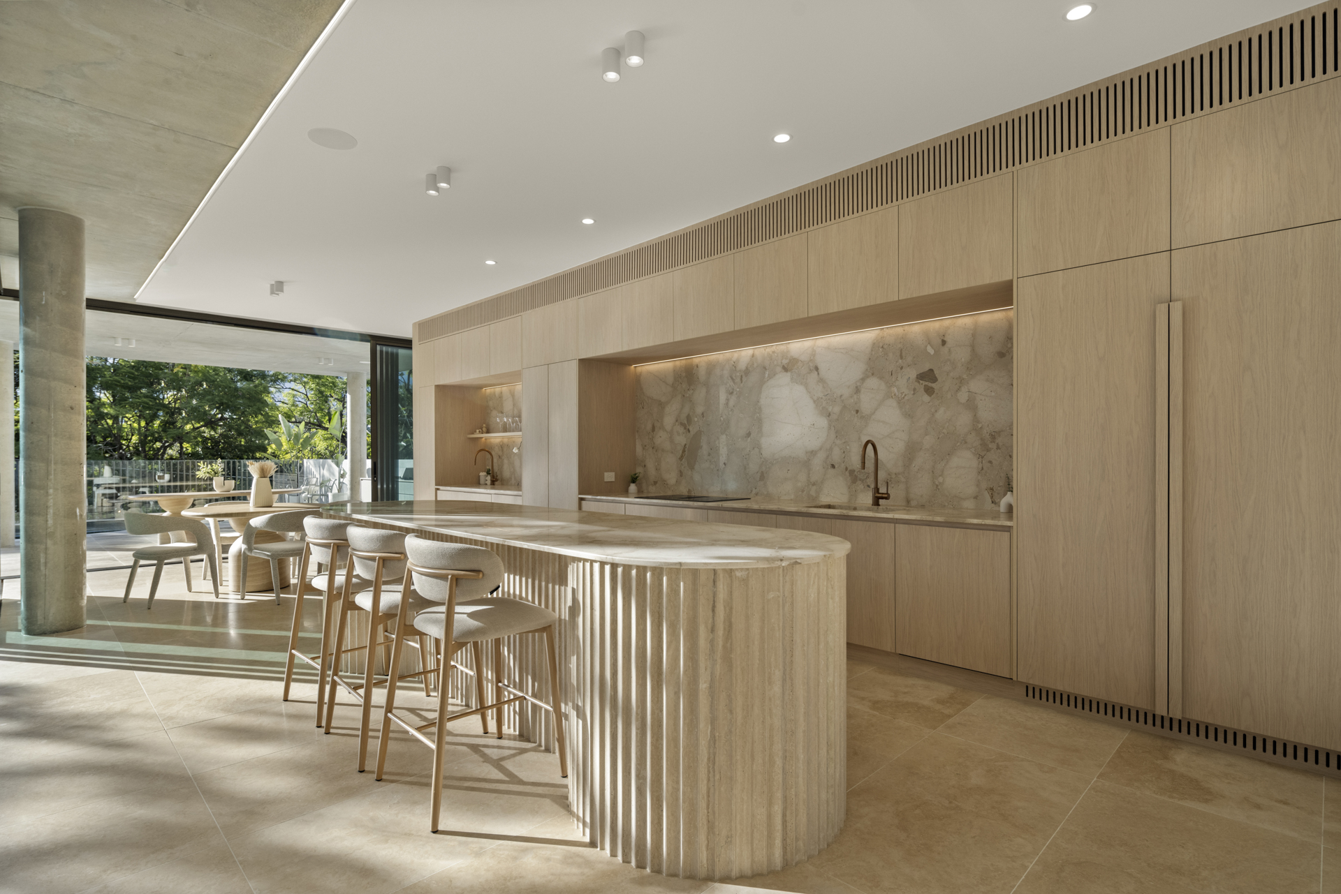 Kitchen joinery and curved stone island in afternoon light