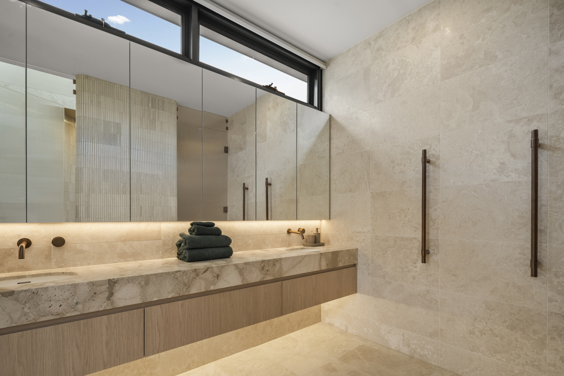 Natural stone bathroom with bronze fixtures