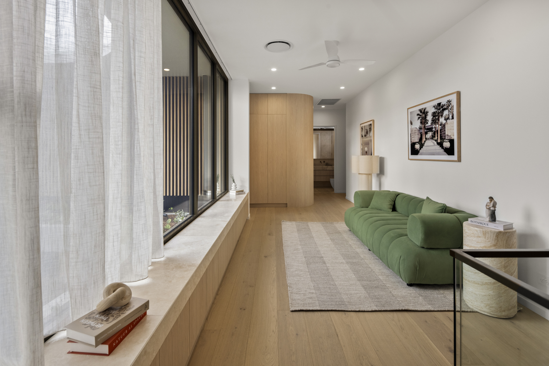 Sunlit lounge with curved green seating