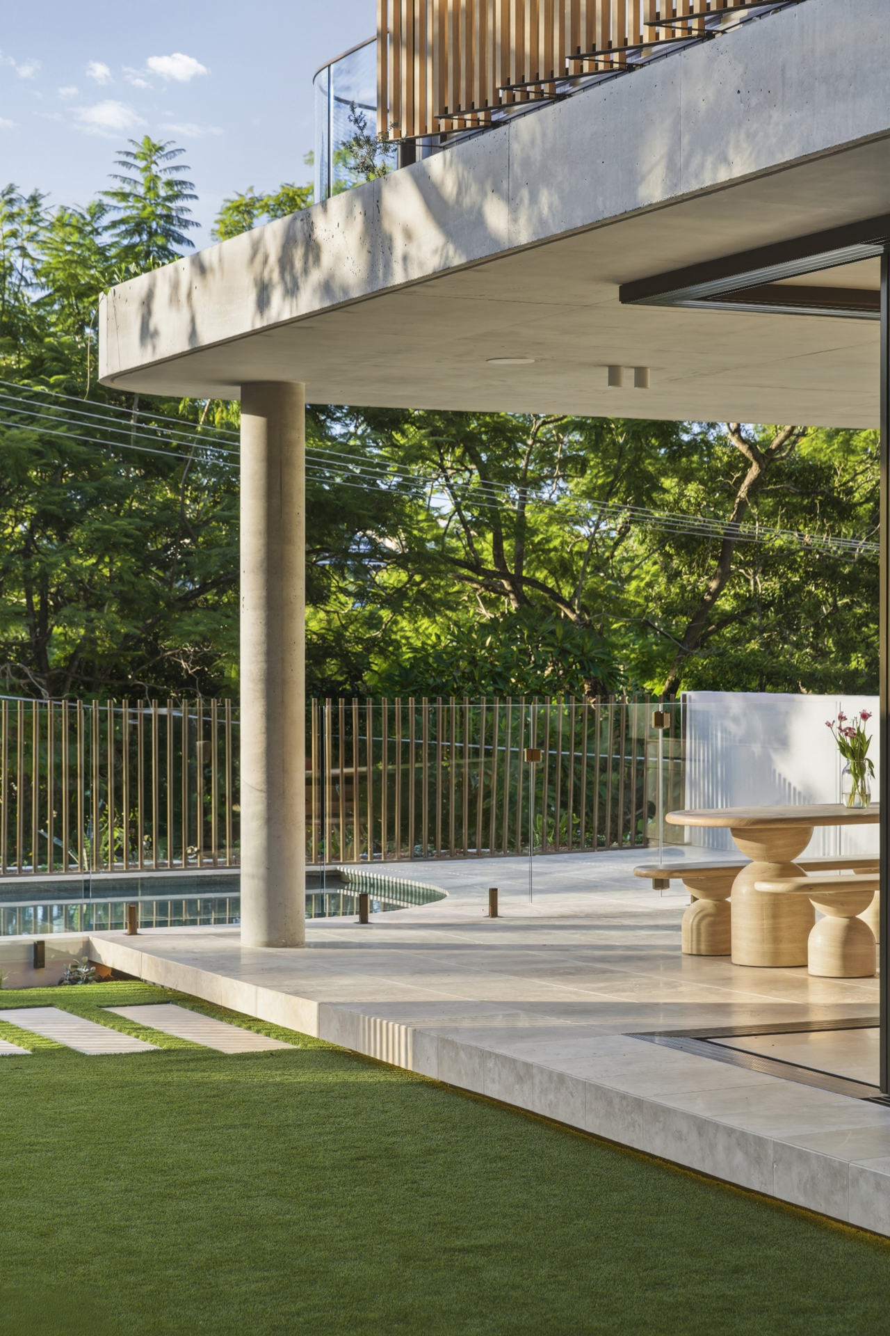Pool terrace framed by curved concrete and subtropical planting